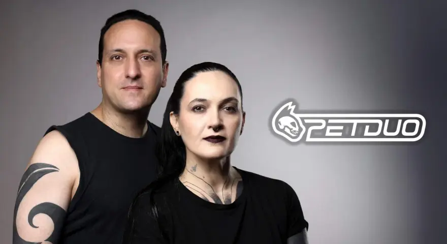Un hombre y una mujer con tatuajes posan juntos. El logo de PETDUO aparece a la derecha.