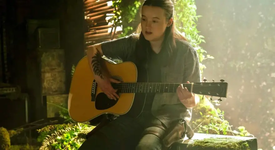 Ellie toca la guitarra, evocando la emotiva banda sonora de The Last of Us.