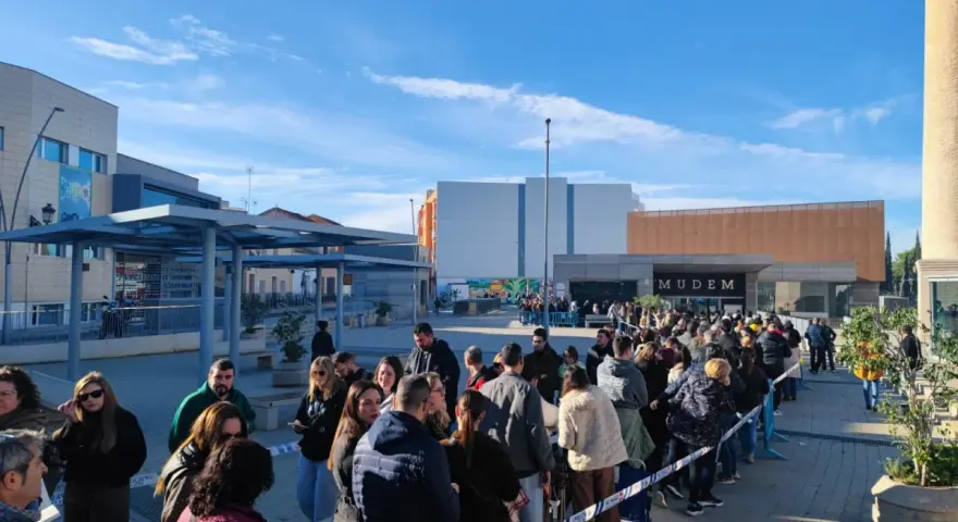 Larga cola de gente esperando para entrar al Mudem, un evento cultural en Murcia.