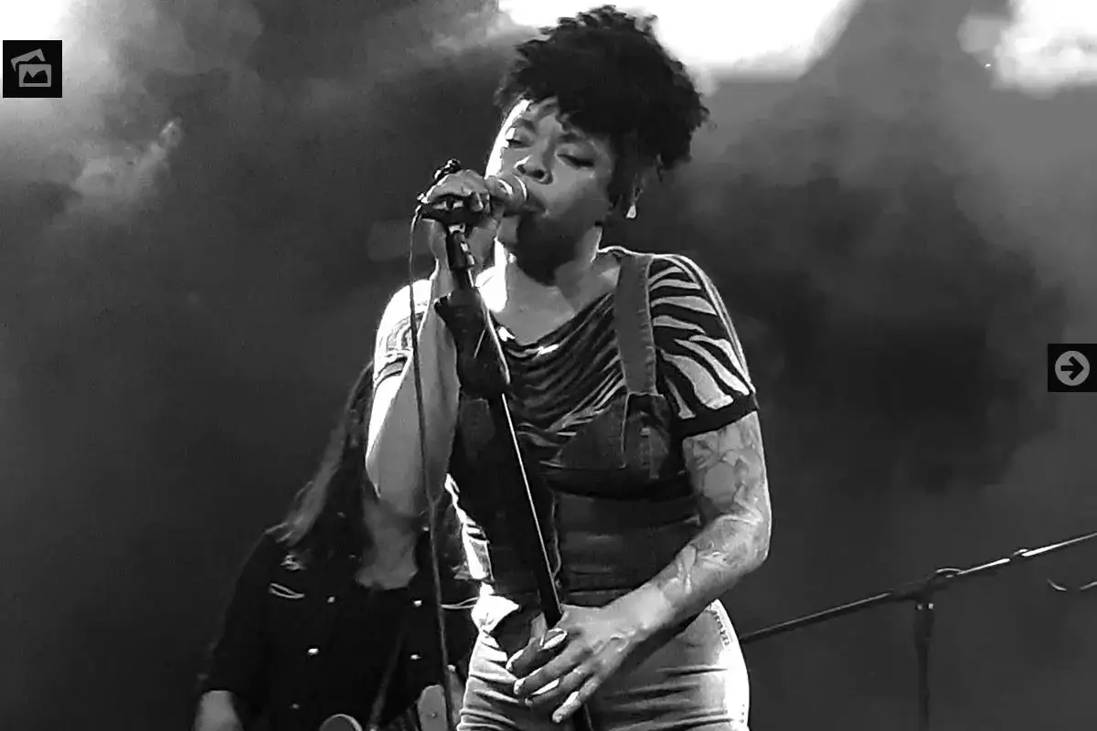 Nikki Hill, con su potente voz, canta apasionadamente en el escenario, envuelta en humo y luces.