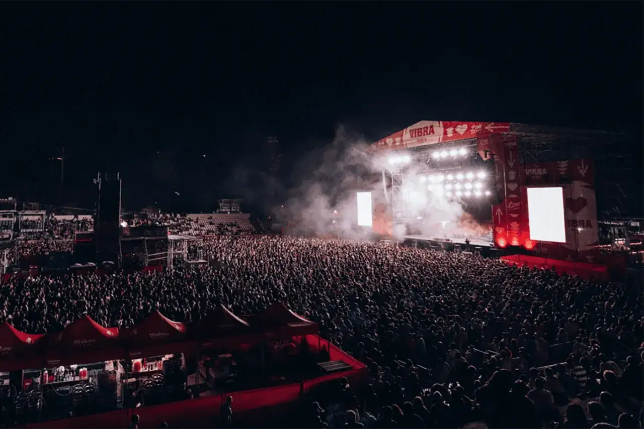 Multitud vibrante en un concierto de festivales metal España. Humo y luces iluminan el escenario principal.