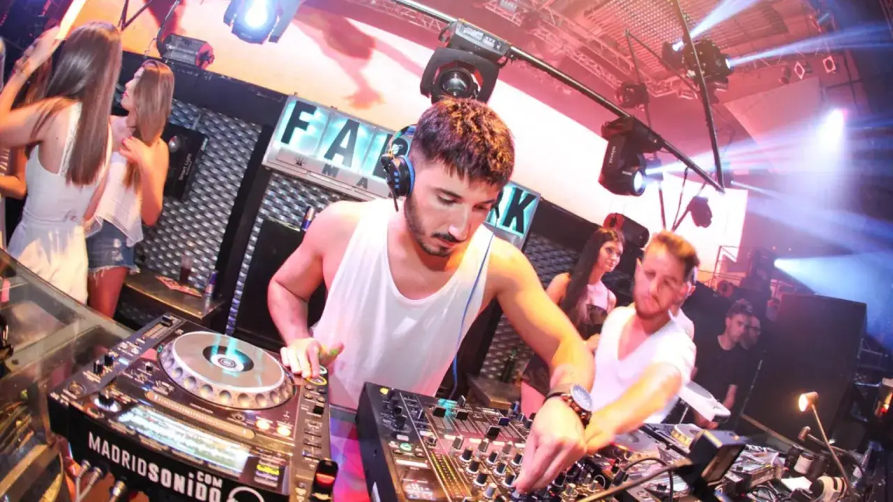 DJ Ballesteros enciende la pista con su música. Luces y gente bailando en un club.