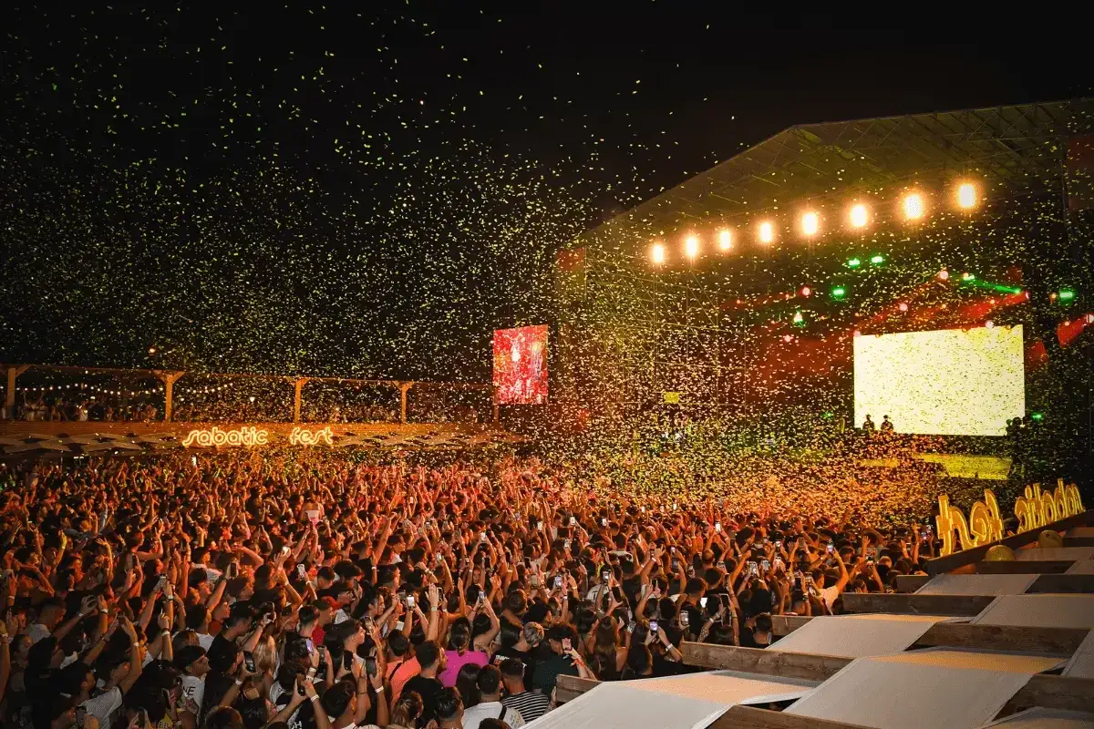 Multitud celebra en el 101 music festival, con confeti dorado cayendo sobre el escenario y el público.