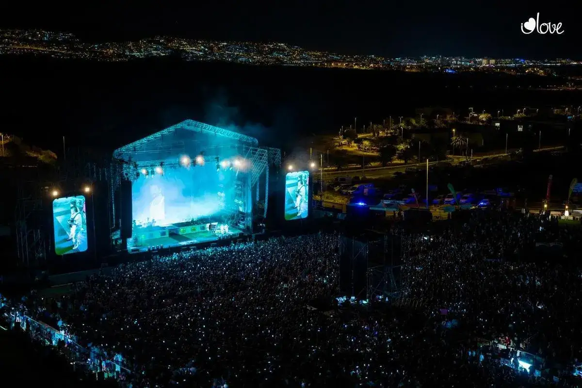 Una multitud ilumina la noche con sus móviles en uno de los conciertos de Camilo, creando un mar de luces.
