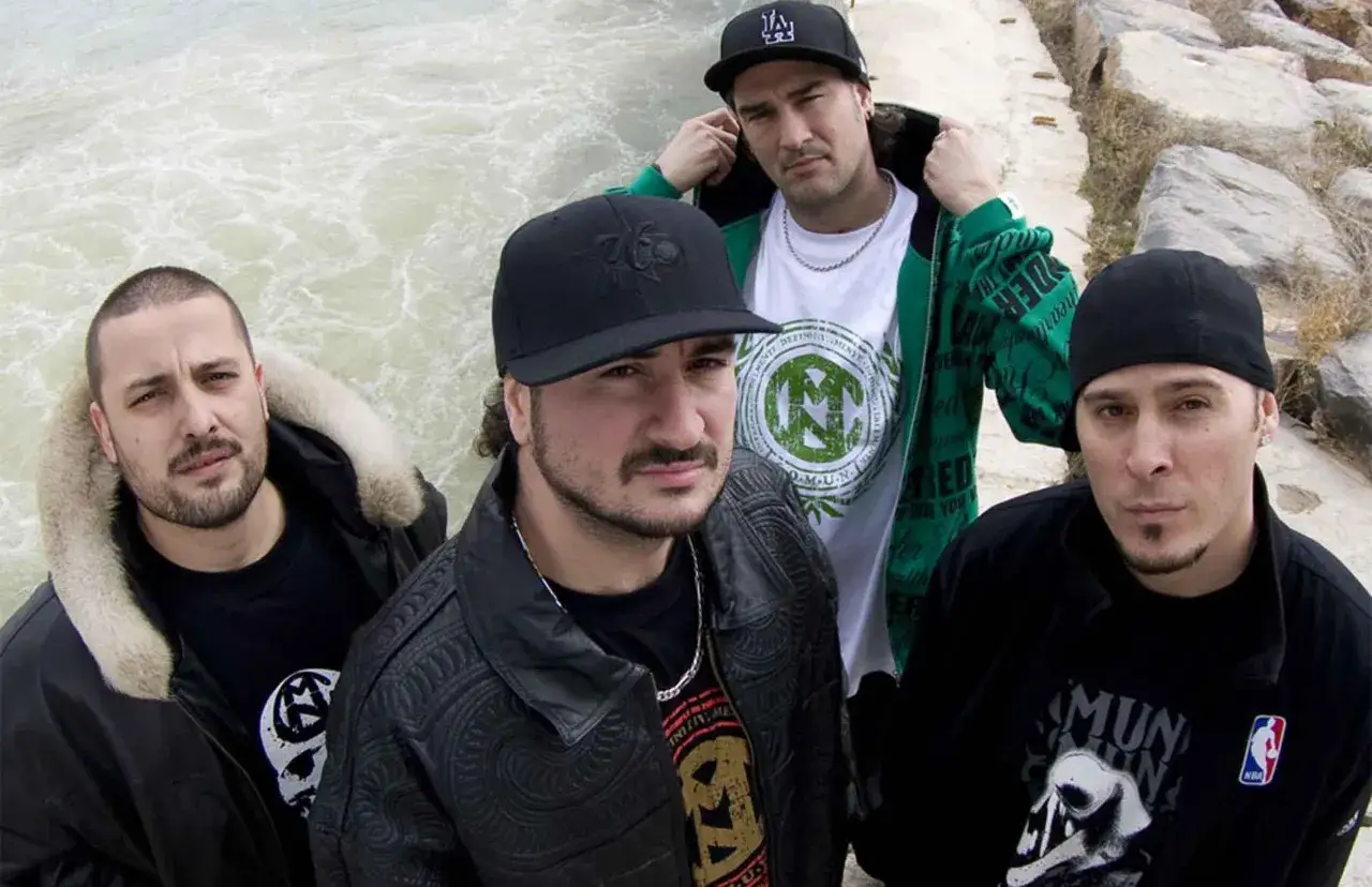 Miembros de Violadores del Verso posan juntos, con gorras y chaquetas, listos para lanzar su próximo éxito.