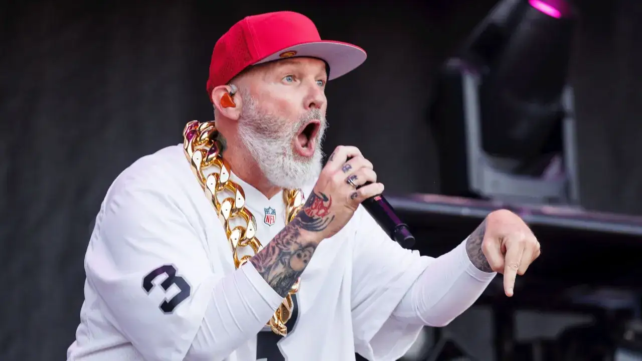 Fred Durst de Limp Bizkit, con su característica gorra roja y cadena de oro, arrasa en un concierto en España.