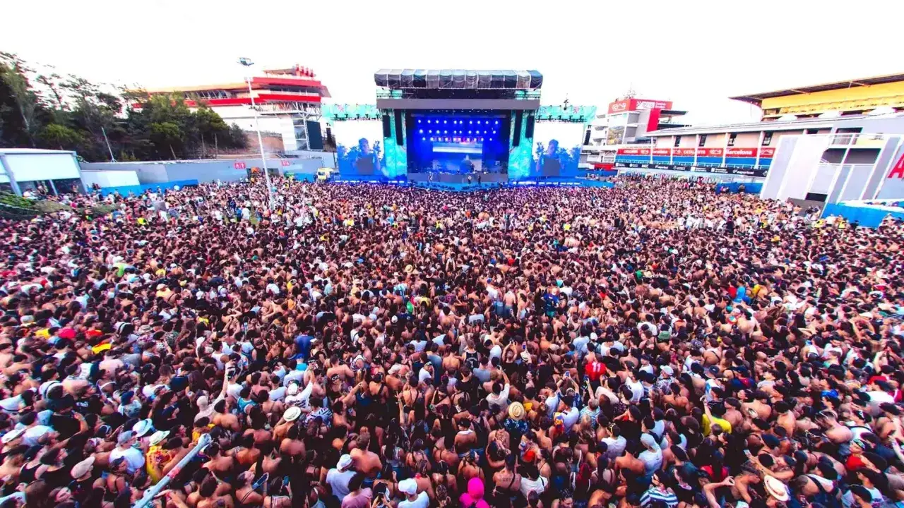 Multitud vibrante en el festival reggaeton Benidorm, disfrutando de la música bajo un gran escenario.