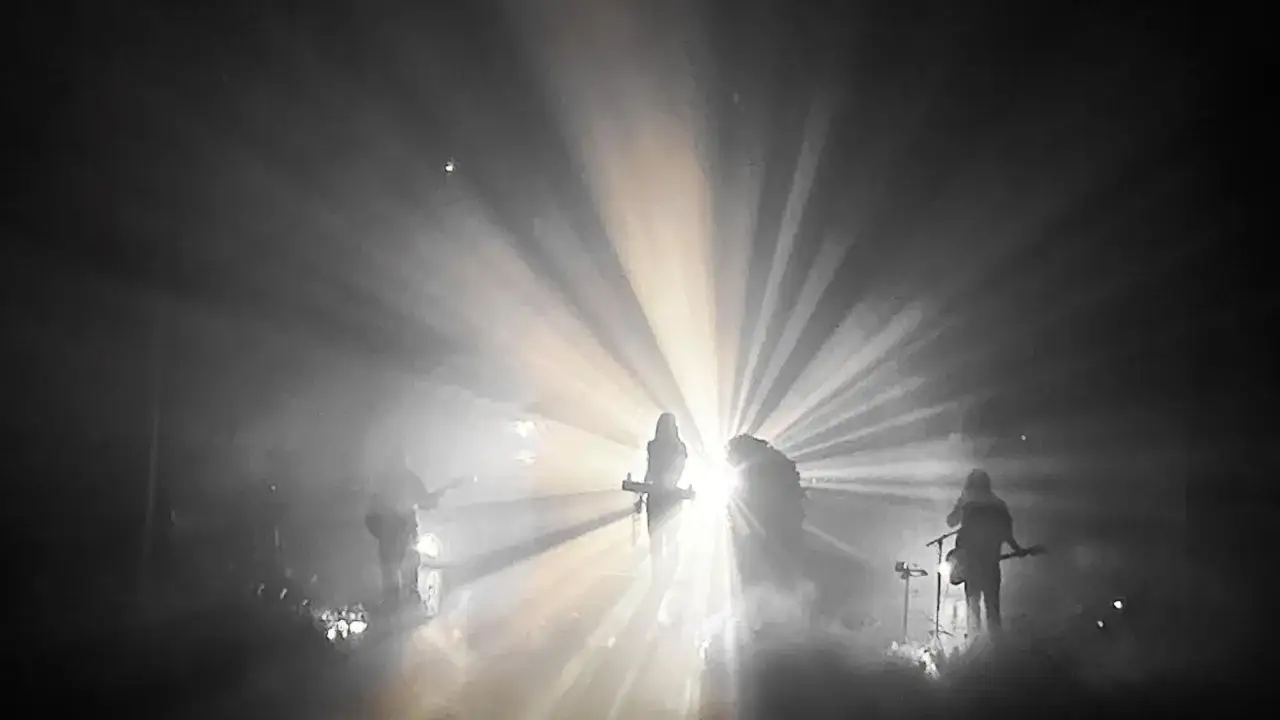 Ethel Cain y su banda envueltos en humo y luces dramáticas, creando una atmósfera etérea en el escenario.