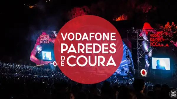 Gran multitud en el festival Vodafone Paredes de Coura, con luces y escenario iluminados.